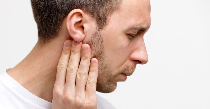 Man suffering from ear and throat pain on one side when swallowing.