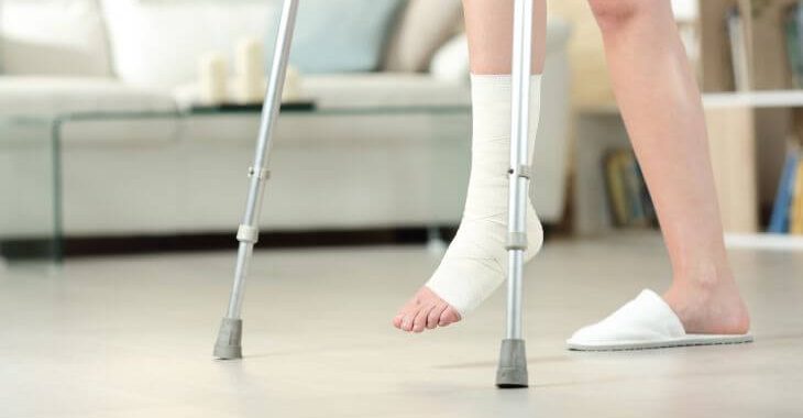 A person with leg injury walking using crutches.