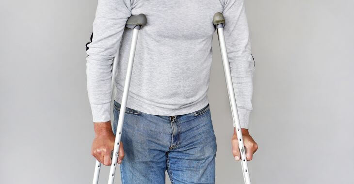 Man walking with crutches.