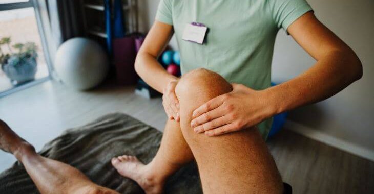 A man suffering from knee arthrosis pain during physical therapy session.