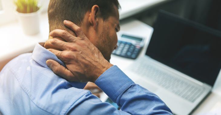 A man touching a lump on the back of his neck.