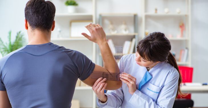 Doctor checking patient's elbow joint flexibility.