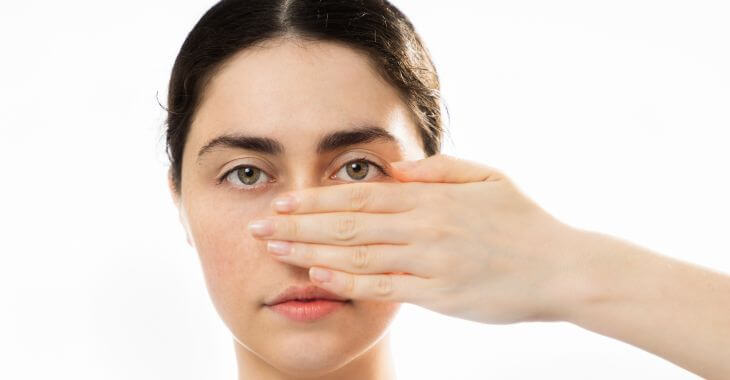 A woman covering her nose with her hand.