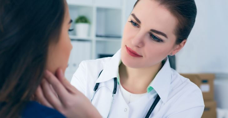 A doctor examining woman's throat.