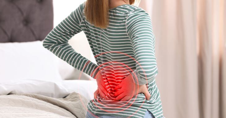 Woman with lower back pain going to sleep.