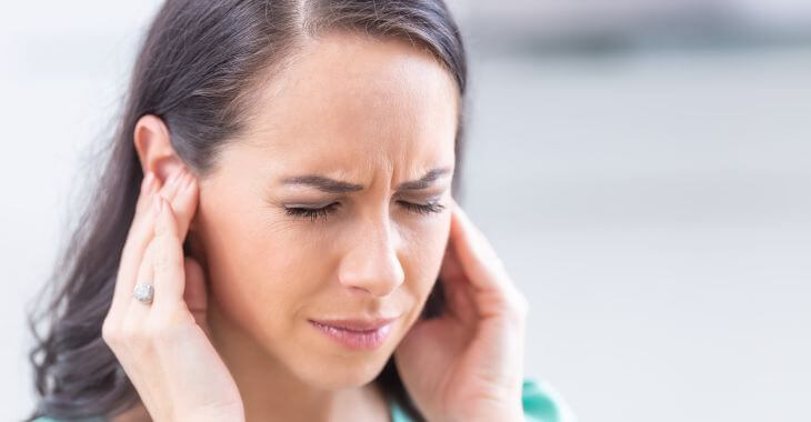 A woman suffering from ear pressure.