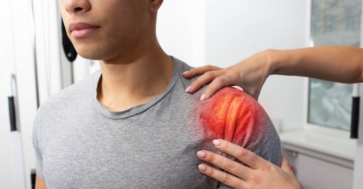 A man with pain shoulder being examined by a doctor.