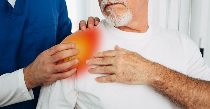 A doctor examining a man with shoulder pain.