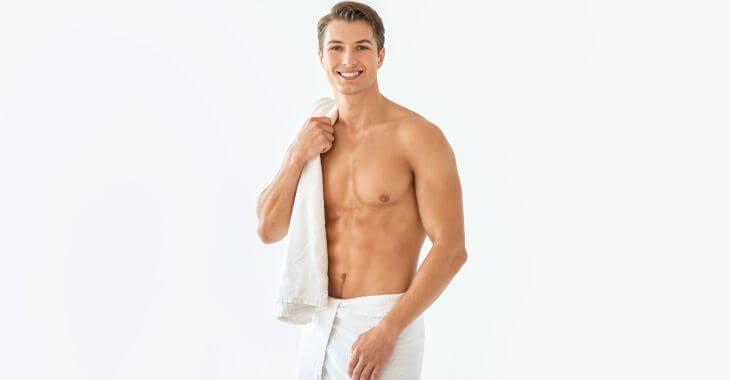 Young slim handsome man with naked torso carrying a towel over his shoulder.