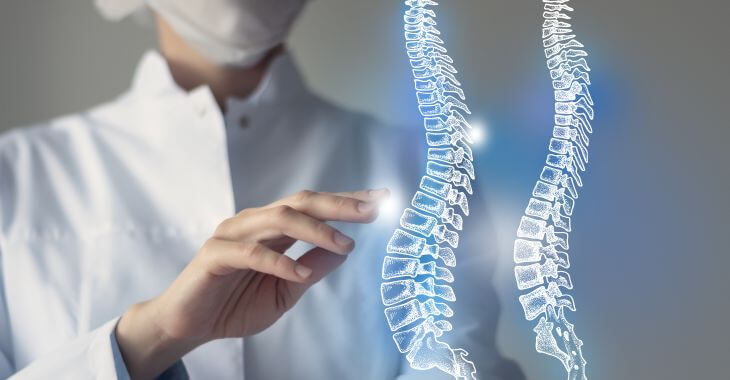 An orthopedic surgeon explaining MILD procedure on a virtual spine models.