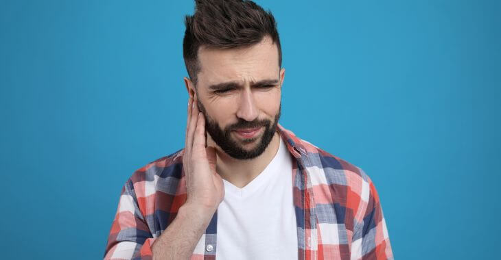 Concerned man touching his ear .