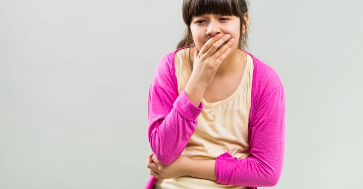 A coughing girl feeling pain in stomach when coughing.