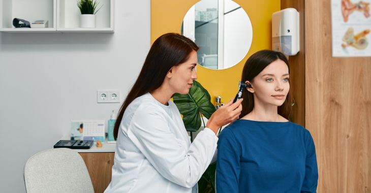 A doctor examining woman's ear.