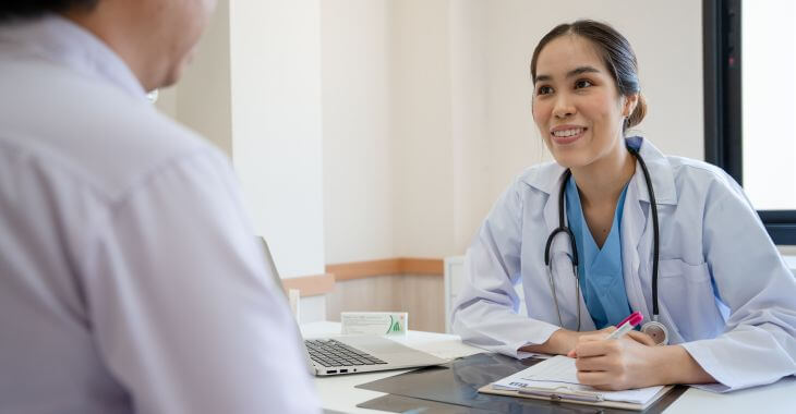 A doctor listening to a patient at a doctor's appointment.