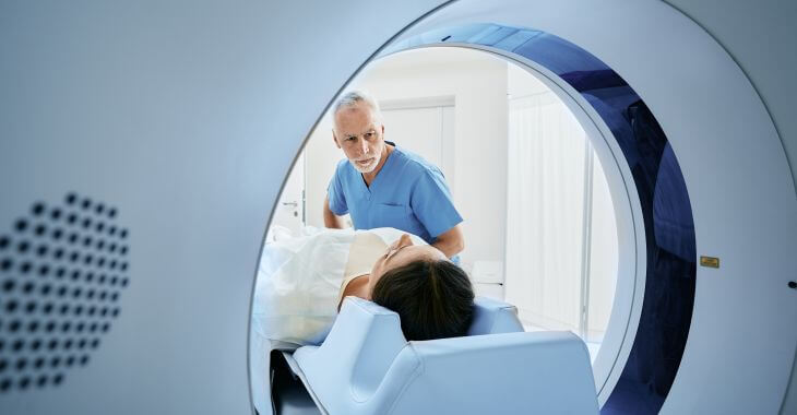 A doctor and a woman undergoing PET or CT scan.