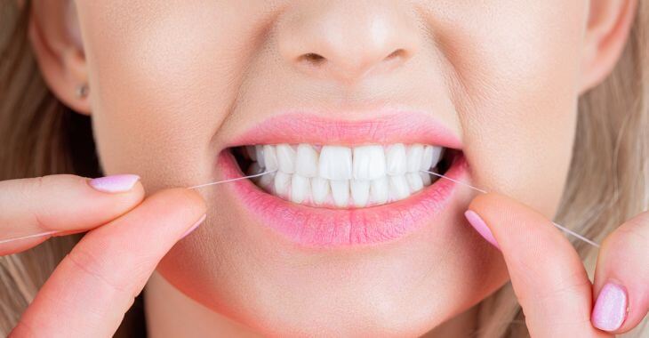 Woman flossing her teeth