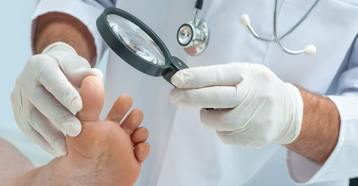 A doctor with a magnifying glass examining patient's toenails.
