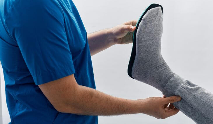 A doctor matching an orthopedic insole to patient's foot.