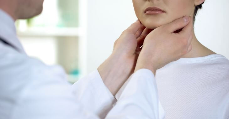 A doctor examining a woman with strep throat.