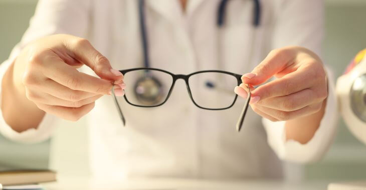 A blurry picture of a doctor holding patient's glasses.