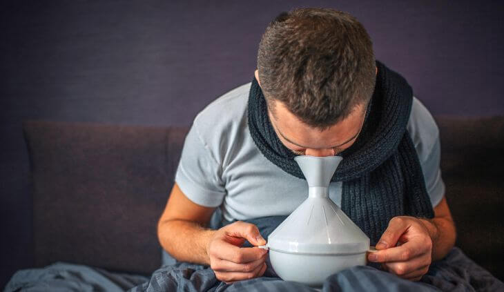 A man breathing in inhalation with essential oil for sinus congestion relief.