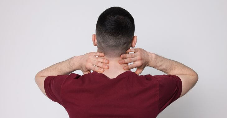 A man touching the back of his neck.