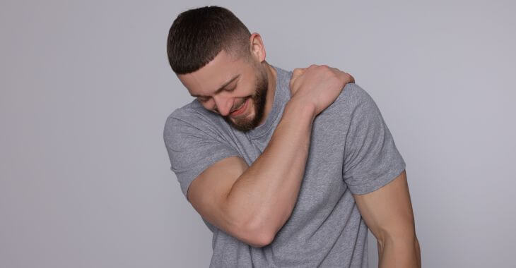 A man suffering pain related to shoulder twitching.