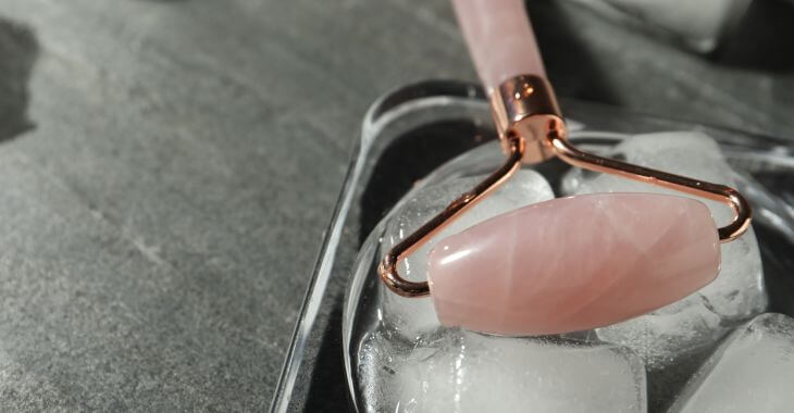 A facial roller in a tray with ice cubes.