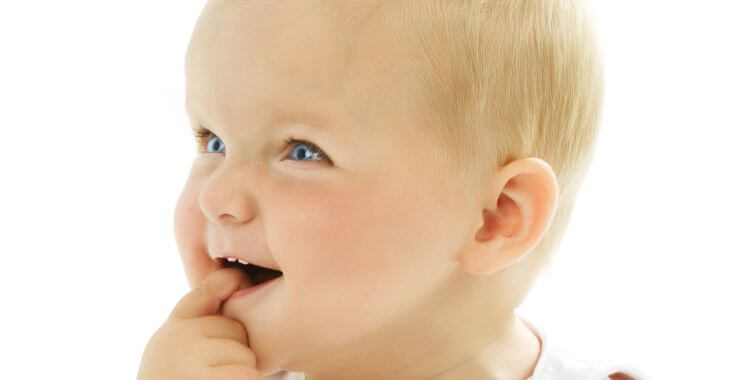 teething baby putting a finger in the mouth