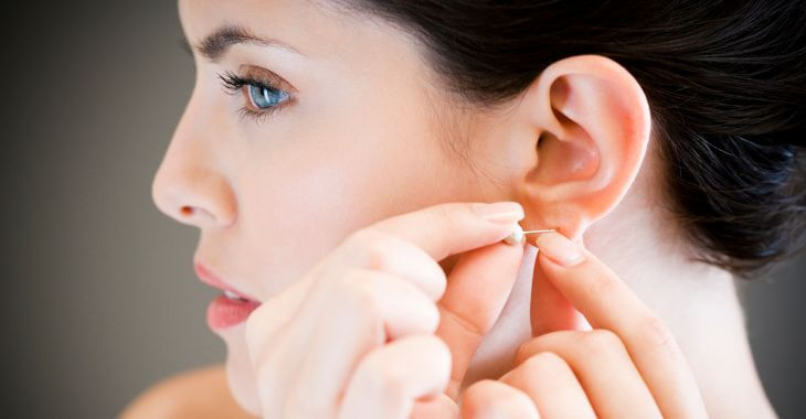 Woman putting on an earring