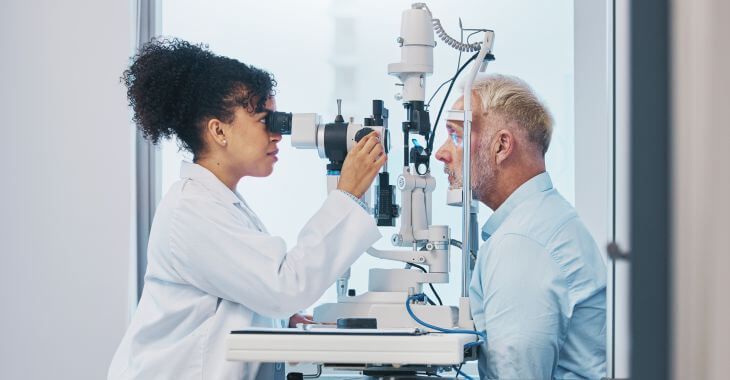 An eye doctor examining male patient's eyes