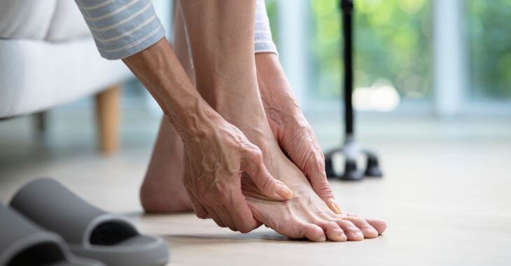 A person touching their bare feet