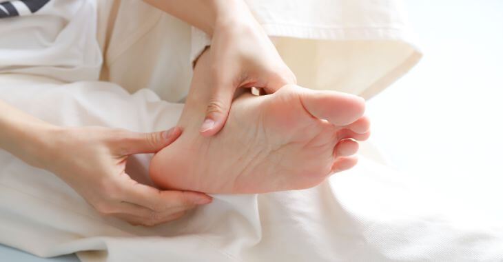 A woman looking closely at her foot and ankle