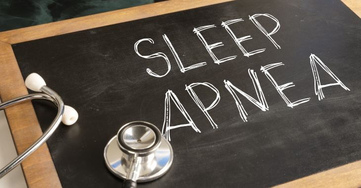 A stethoscope an a board with written text saying Speep Apnea on a desk of a doctor