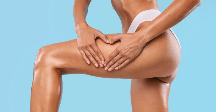 A slim woman with perfect legs keeping hands in the shape of heart on the outer side of her tigh