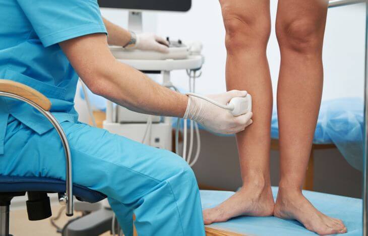 A vascular surgeon checking veins on patient's legs