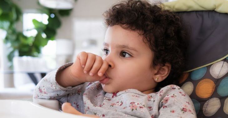 A toddler sucking thumb to comfort himself