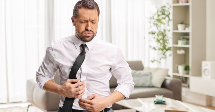 A businessman feeling bloating and discomfort